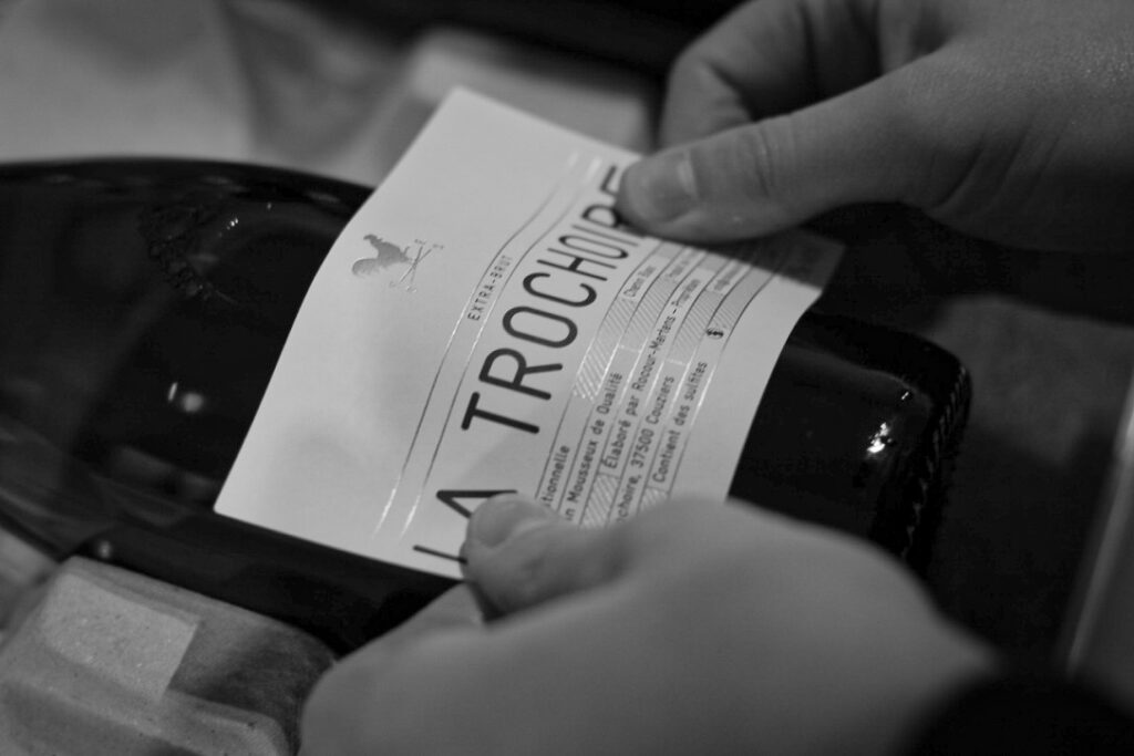 Collage à la main d'une étiquette de vin